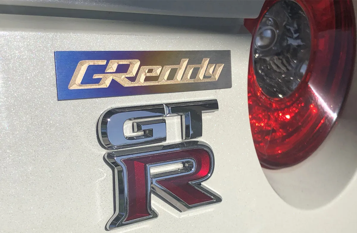 GREDDY TI PLENUM EMBLEM (105x20MM) - (18000201)